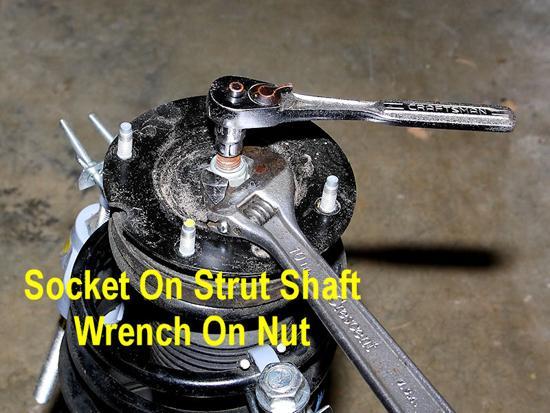14. Use a 21mm open end wrench (or an adjustable wrench) to hold the strut s nut, while turning the