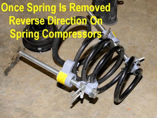 16. Reverse the turning direction of the spring compressors to expand them, switching between them every