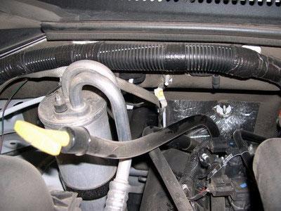 Remove cover and hose as an assembly. a. Remove wire harness from stud on driver side valve cover bolt.