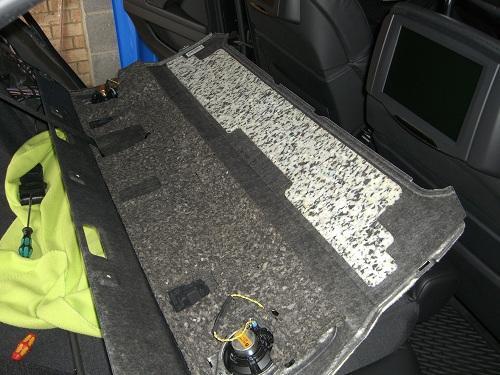 Once the speakers are disconnected, the shelf will come out still attached to the seat belts. Next we need to remove the floor in the boot (trunk).