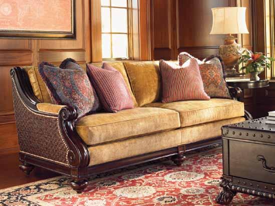 The sofa features generous scroll carvings on the arm and elegant woven accents on the ends.