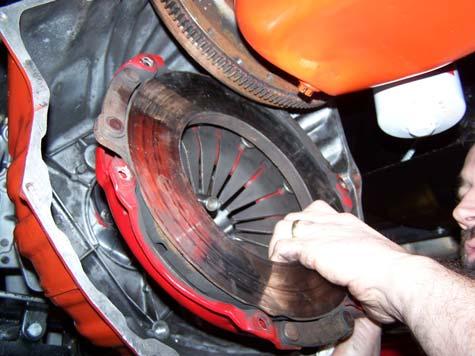 Raise transmission nose enough to insert clutch disc into bellhousing against flywheel and fully insert modified alignment tool through clutch disc and into pilot bearing.