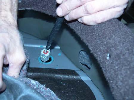 23. Insert the rear connector of the supplied chassis harness into the hole in the floor pan of the under seat storage