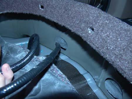 Seat the grommet affixed to the supplied chassis harness in the hole in the floor pan of the under seat storage
