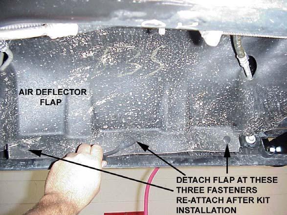 Detach the front edge of the air deflector flap from the bottom of the bumper. It is held in place with three plastic push-in fasteners.