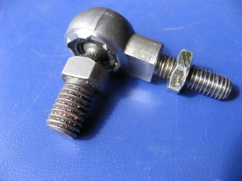 Shown below is another pic of the stock Toyota part. It has a 12mm male thread that fastens to the lever and a 10mm male thread that screws into the cable and is held with a locknut.