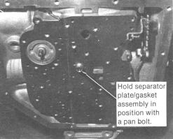 Install upper valve body gasket in position on the transmission case side of the separator plate. Use a small amount of grease to hold it in place.