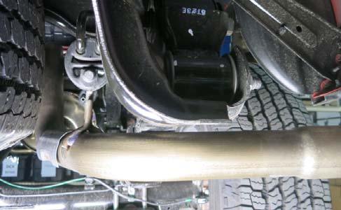 -4 (e) Pry the front muffler exhaust bracket loose from the rubber