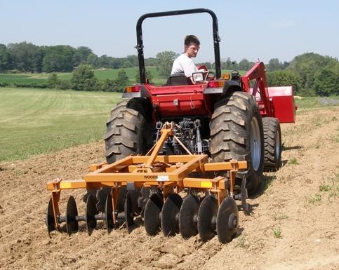 be set at a variable angle to the line of motion. As the harrow is pulled ahead, the discs rotate on the ground. The disc harrow in field operation is shown in Plate 14.1. (Courtesy: http://www.