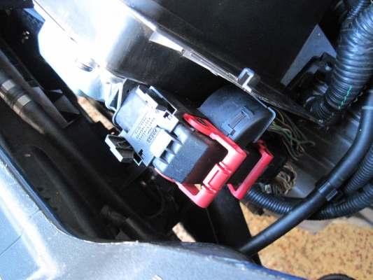 3. Unplug the two ECU wire harnesses by depressing tabs and rotating red levers.