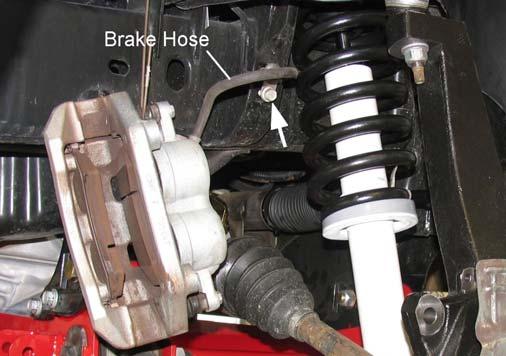 Attach the front caliper to the steering knuckle with the original mounting bolts. Tighten the caliper mounting bolts to 130 ft. lbs. 4) Remove the brake hose banjo bolt at the caliper.