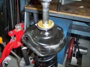 9. Using a spring compressor, compress the spring