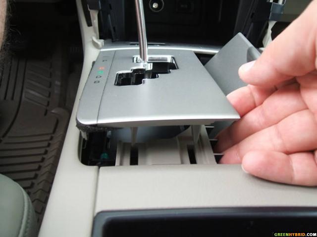 Third step: Open the cupholder door and remove the shift cover plate starting from back and moving slowly to the front,