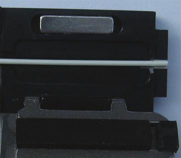 Once the fusion splicing cycle is completed, remove the connector from the splicer and slide the splice protection sleeve up to cover the splice.