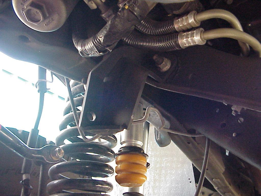 Remove the steering stabilizer bracket located on the passenger side of the engine cross member: Remove the stud end of the stabilizer from