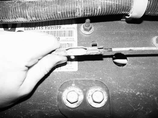 Figure 12 17. Remove the front half of the parking brake cable from the body mount. Compress the retaining tabs with pliers and push the cable through the hole Figure 13. Figure 13 18.