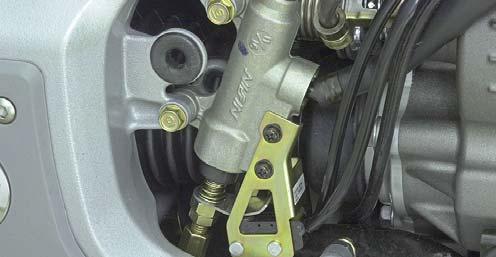 Remove the right engine side cover. Look for a punch mark on the rear master cylinder lower mounting tab as shown.