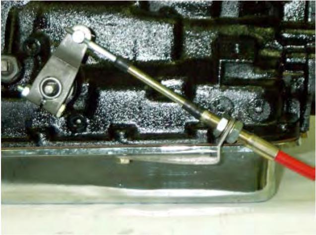 C-6: Remove the two transmission oil pan bolts from the left rear corner of the oil pan. Install the cable bracket into position with the two spacers between the pan and the bracket (See Photo #8).