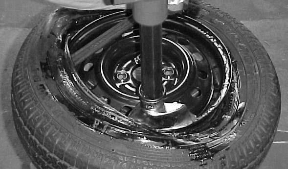3. Depress the right front pedal ( TURNTABLE ROTATION CONTROL ) to rotate the turntable clockwise. The mount/demount head will guide the tire bead over the edge of the wheel as the turntable rotates.