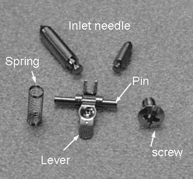 Remove metering lever, pin, metering lever spring and inlet needle valve. Inspect the metering lever. It should not be worn where it contacts the inlet needle valve and metering disk.