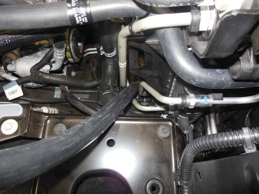 117. Slide the long straight section of the Pump to Lower LTR hose through the space