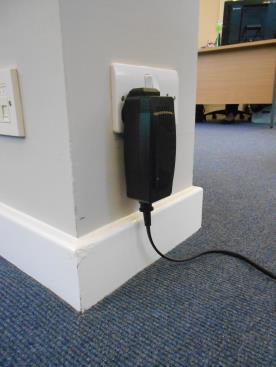 Unwind the charge cable from the hooks and plug the charger into a suitable mains power supply.