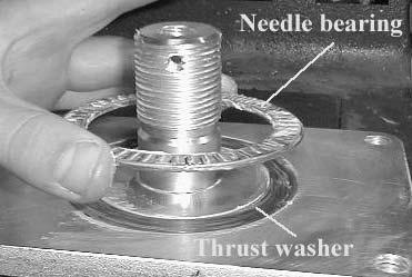 Install the new thrust washer onto the swivel plate weldment. 12. Grease the new needle bearing and position on top of the new thrust washer.