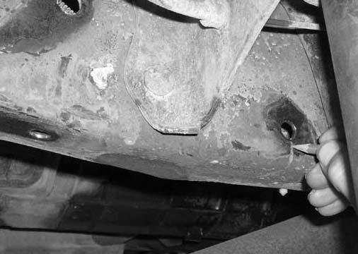 Working on the driver side, remove the stock nut that connects the stock transfer case cross member to the stock frame