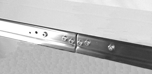 On tension end of the conveyor identified with label (R of Figures 5 & 6), loosen screw (S of Figure 5).