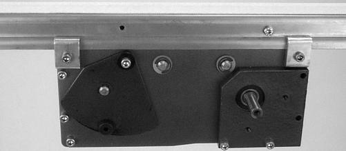 On tension end of the conveyor identified with label (R of Figures 19 & 20), loosen screw (S of Figure 19).