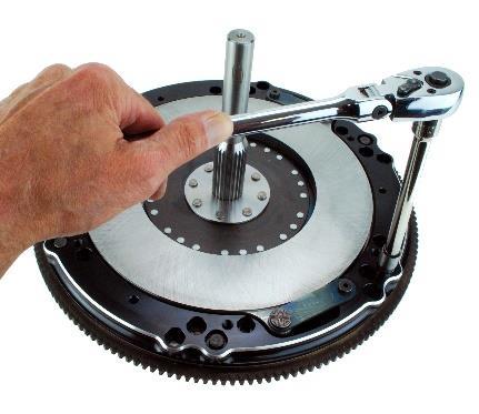 Set the flywheel on a bench, and place the bottom disc on the flywheel (fig a), followed by the base