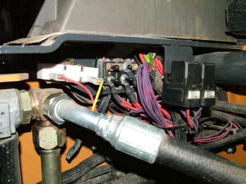 Route the wire harness to the skid steer wire junction area, just below the fuse box on the left side.