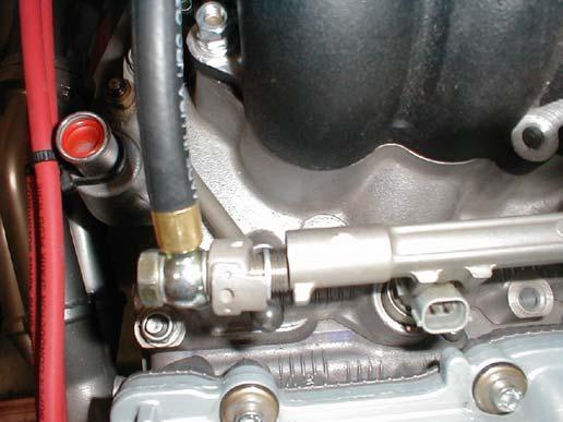 Install the fuel injector block gasket and block onto the supercharger. The electrical connector of the injector should be up and the fuel supply banjo fitting hole facing down.