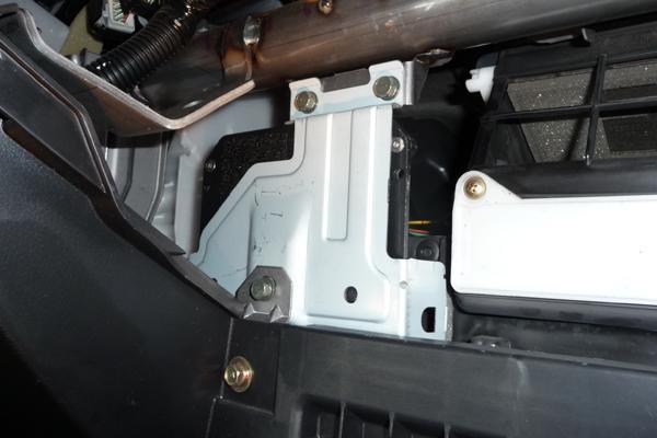 12 3511 - Mitsubishi EVO 8 10. Line the OEM ECU bracket with the 2 threaded mounting holes. Note: the comms cable will be a tight fit. Reinstall the two M6 bolts (shown) using a 10mm socket wrench.