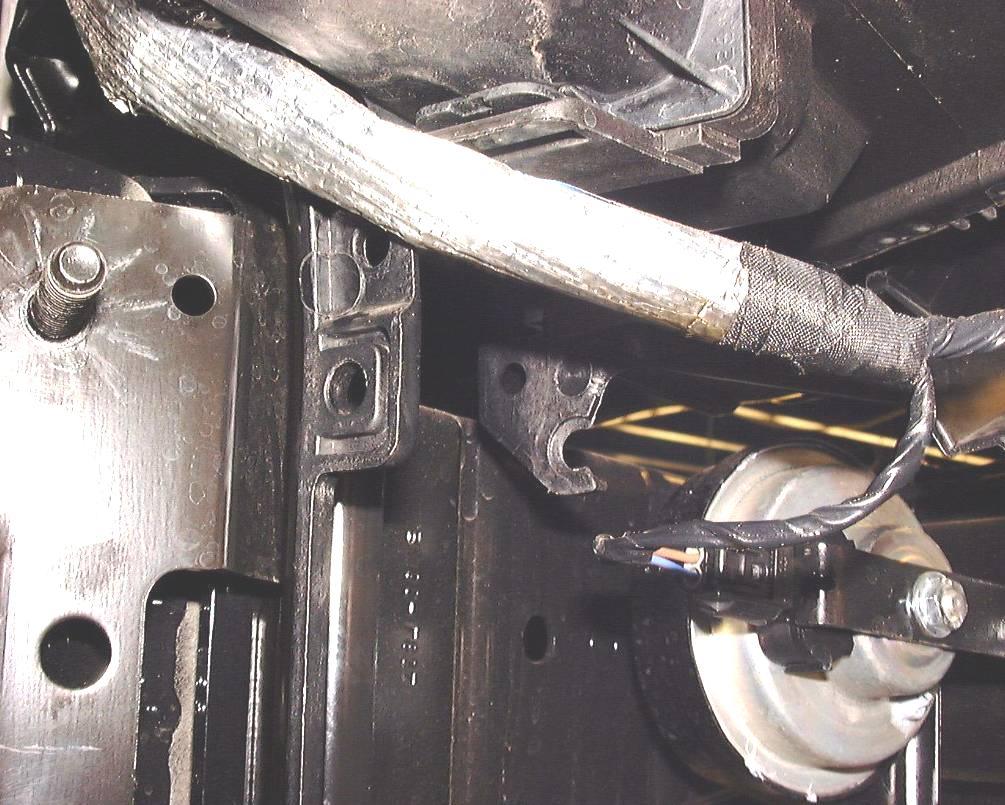 21. Remove the stock headlight support bracket (note the bracket has been removed in the view below) see figure 20. Some cars do not come with these brackets.