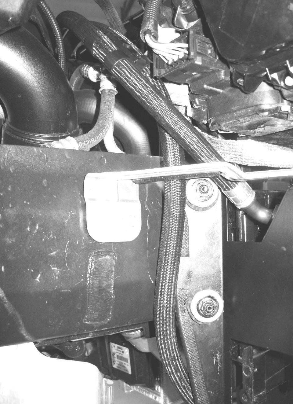 Do not tighten yet. Leave the aluminum Oil Cooler Retaining Strap on the Cooler Assy until after the Oil Lines are fully tightened.