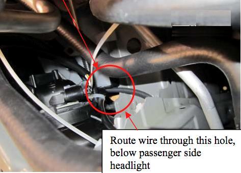 Continue routing the wire harness through the opening under passenger side headlight.