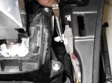 To adjust the shifter cable, place the shifter in 4th gear. Pop open the grey cap on the cable housing and move the shifter back slightly, and close the cap on the cable housing to secure the cable.