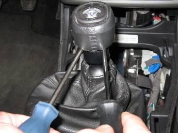 Page 5 10. USE CAUTION DURING THIS STEP: To remove the shift knob, insert 2 equal size flat head screwdrivers between the shift knob and the top of the reverse lock as shown.