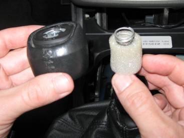 While one person pries upward on the shift knob, the other can pull upward on the shift knob to separate it from the shaft.