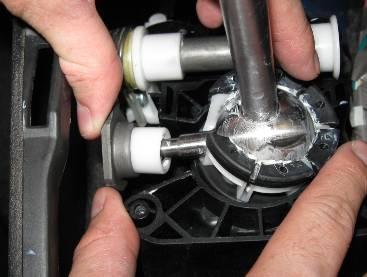 With the short shifter and pivot cup seated in the shift assembly, slide the white plastic cup on the side arm of the short shifter in to the steel L shaped