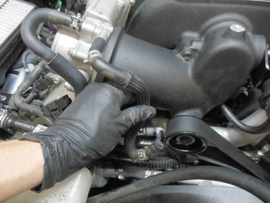 Install the other hose to the front facing tube on the throttle body. Install the other end to the coolant cross over. Slide the clamps over the connections. 123.