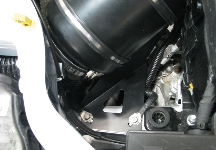 You can now drop the airbox into place, feed the duct through the gap alongside the radiator that goes