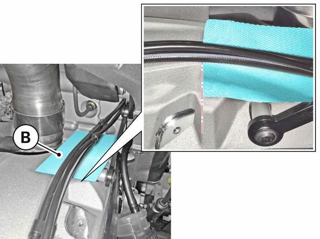 reflective sheath (B) below the rear brake hose, shock absorber adjustment cable and rear speed sensor