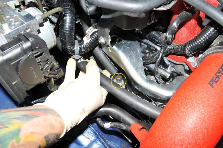 38. Using the remaining length of ½ hose, route between the main harness and over top the injector cover