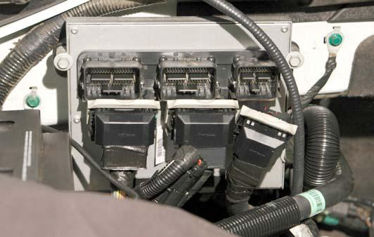 13. Unlock the three vehicle computer connections by pulling the grey release levers forward.