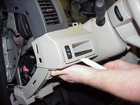 Remove the two top cover-to-instrument panel retaining screws located at the back of the instrument panel cluster opening