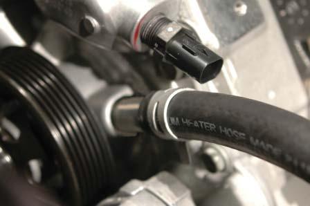 Route the hose forward on the driver side along and below the coil packs, under the intake air fi lter box location and