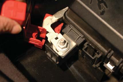 101. Remove the red wire cover from the positive (+) terminal on the outside of the fuse center box by
