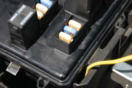 105. Open the fuse center cover and route the yellow wire up
